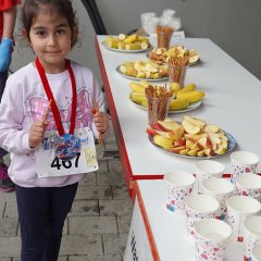 Auf dem Bild sieht man ein Tisch mit Obst und eine kleines Mädchen