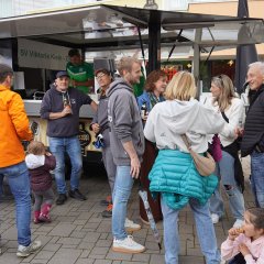 Auf dem Bild sieht man die Menschen am Getränkestand stehen