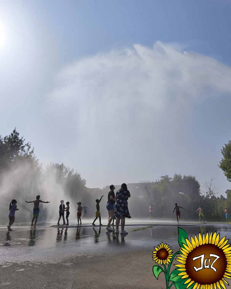 Ferienspielwoche mit Motto Sport und Bewegung Im Foto sieht man die Kinder, die durch den Löschregen laufen