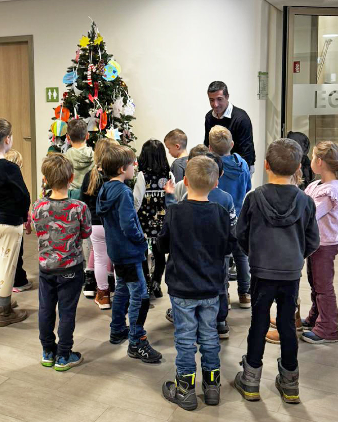 Weihnachtsbaum im Rathaus-Foyer Im Foto sind die Kinder mit Bürgermeister Mark Pullmann vor dem geschmückten Weihnachtsbaum im Rathausfoyer zu sehen.