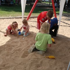 Die Kinder spielen mit Sand an der Jubiläums Programm der KITA Wichernweg