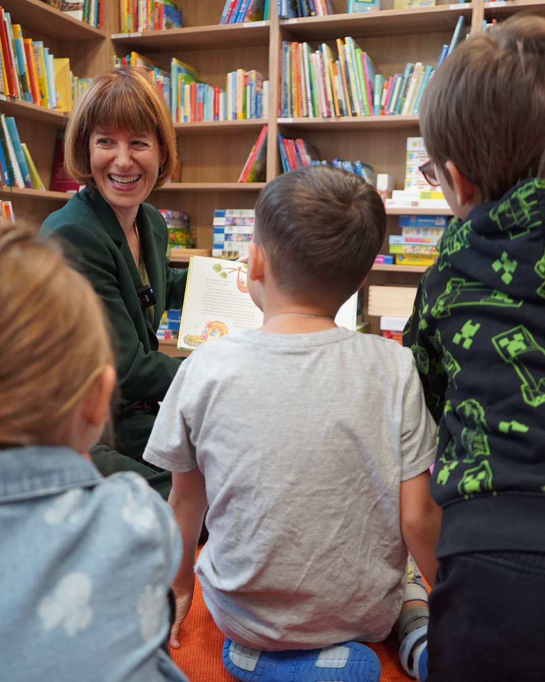 Auf dem Foto ist die hessische Ministerin beim Vorlesen für Kinder zu sehen