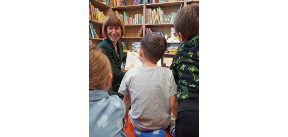 Auf dem Foto ist die hessische Ministerin beim Vorlesen für Kinder zu sehen