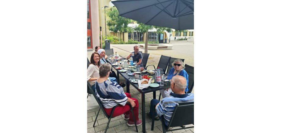 Teilnehmende beim Frühstücken im Außenbereich des ZIMMnERs