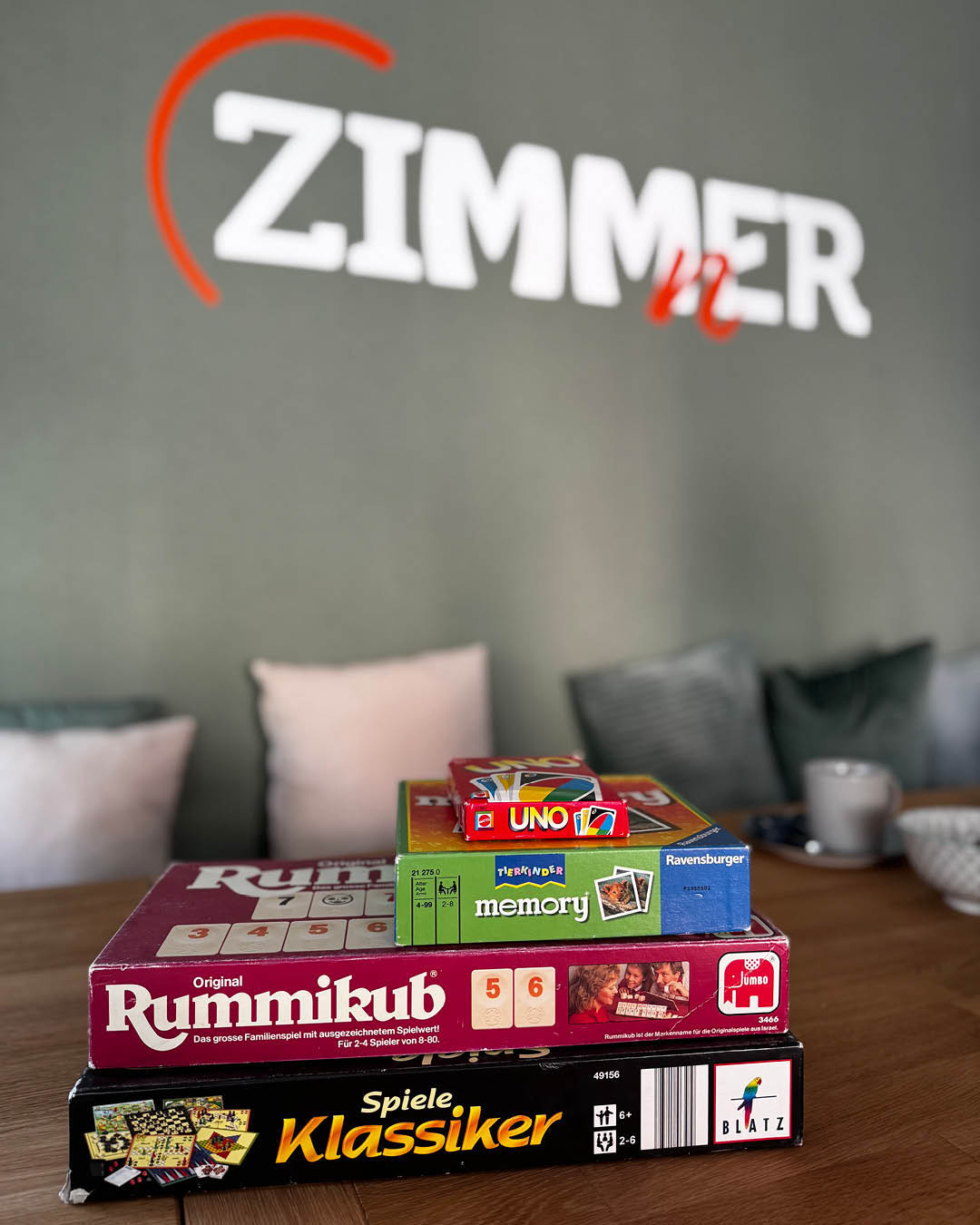 Auf dem Foto sieht man Gesellschaftsspiele auf dem großen Tisch des ZIMMnERs