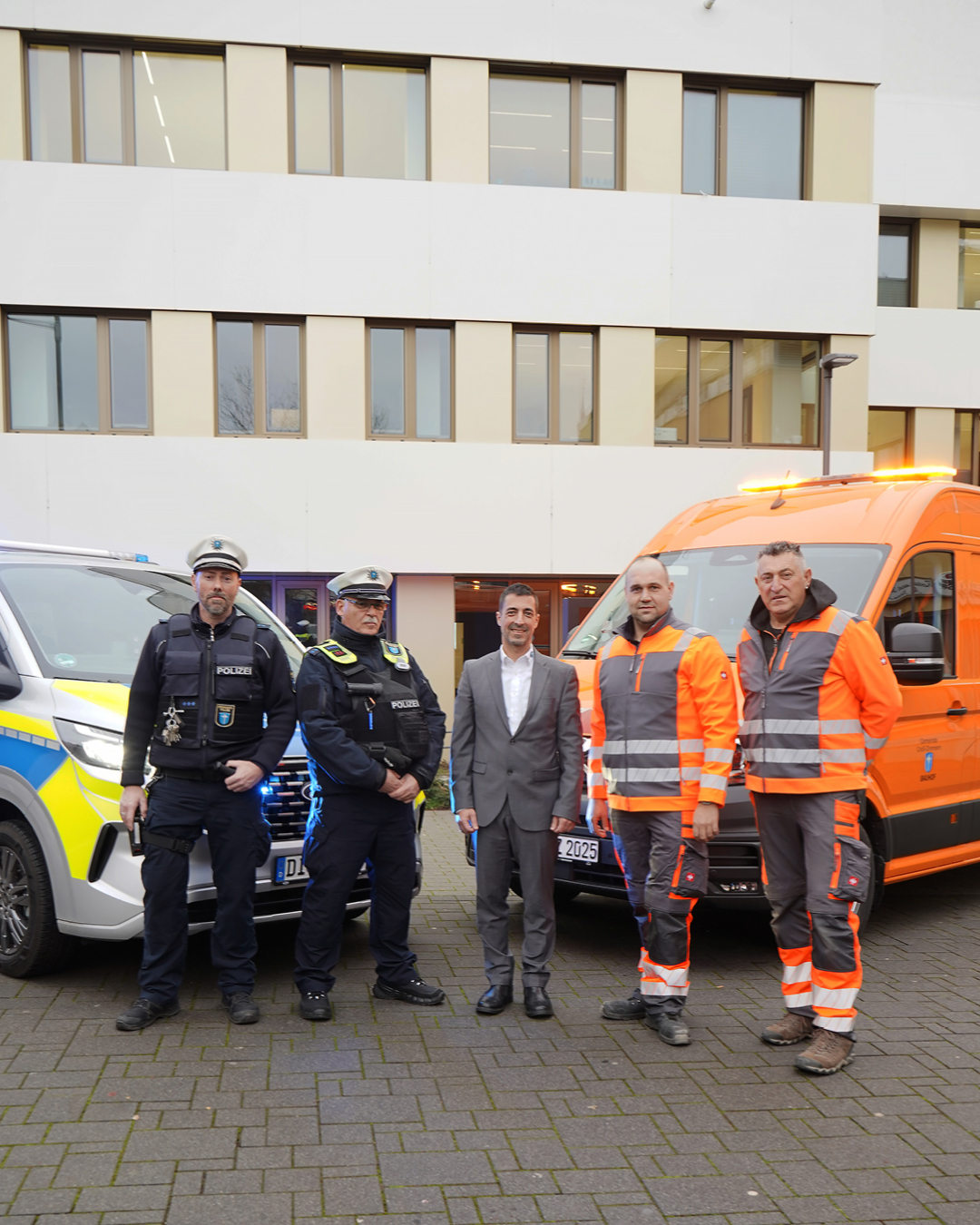 Im Foto ist das neue große Fahrzeug des Ordnungspolizei links und das des Bauhofs rechts und davor jeweils zwei Mitarbeiter der zuständigen Stellen, in ihrer Mitte Bürgermeister Mark Pullmann