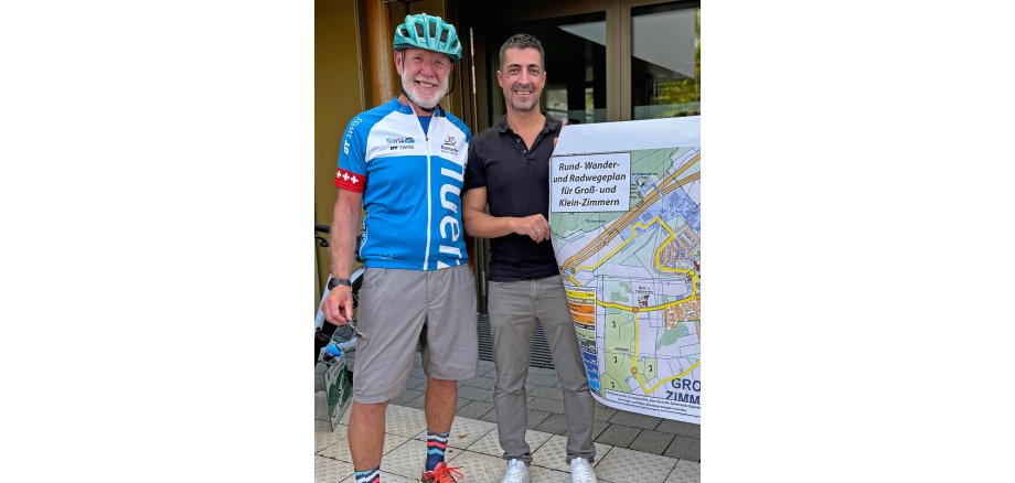 Auf dem Foto sind die beiden mit dem Plan Radrundweg zu sehen