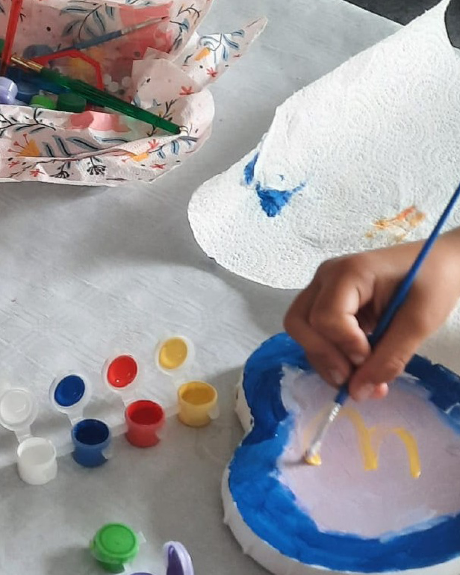 Auf dem Foto sieht man einen Teilnehmer beim Bemalen der Leinwände